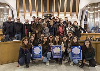 Foto di gruppo dei partecipanti alla conferenza stampa del 10 gennaio: con gli allievi della terza media di Mombaroccio sono, da sinistra, il Vicesindaco di Mombaroccio Mauro Ferri, il giornalista Roberto Mazzoli, il Presidente della Provincia di Pesaro e Urbino Giuseppe Paolini, il Sindaco di Mombaroccio Angelo Vichi, la dirigente scolastica Cinzia Biagini, gli insegnanti della scuola di Mombaroccio Elisa Buoncompagni e Michele Alexis, Patrizia Paoloni, membro del Comitato d'Onore di nomina provinciale e M.Lorena Farinelli, funzionario dell'Ufficio Scolastico Provinciale.